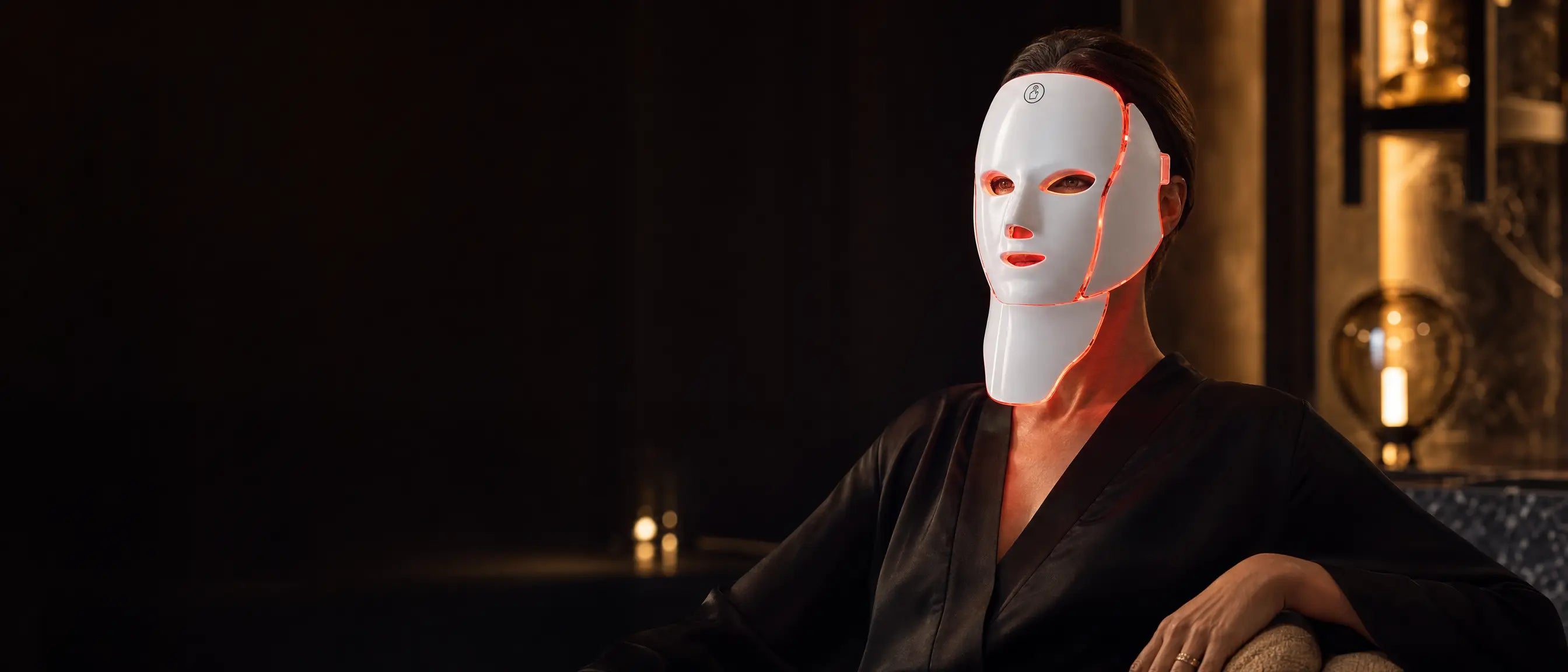 woman wearing LED face and neck light therapy mask